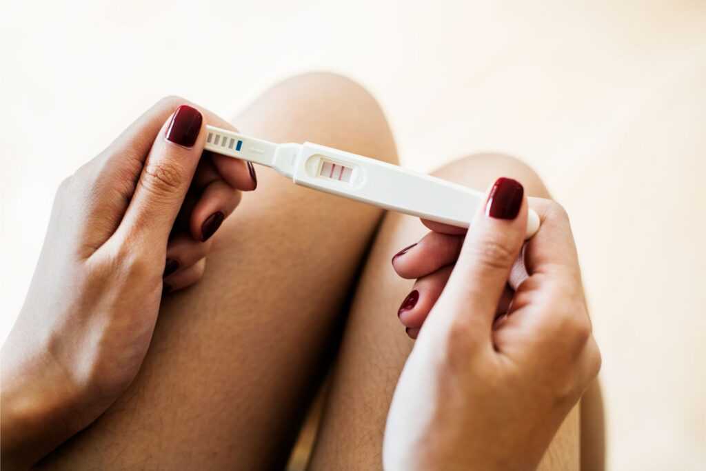 woman holding positive pregnancy test